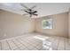 Spacious bedroom with tile flooring, ceiling fan, and ample natural light, offering a versatile living space at 830 N Sunset Dr, Mount Dora, FL 32757