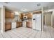 Functional kitchen with white appliances, wood cabinetry, and easy-to-clean tile flooring, ideal for Gathering meals at 830 N Sunset Dr, Mount Dora, FL 32757