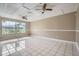 Bright living room featuring tile floors, a large window, and modern ceiling fans for a comfortable atmosphere at 830 N Sunset Dr, Mount Dora, FL 32757