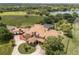 Aerial view showcasing the home's sprawling layout, circular drive, and lush landscaping at 9400 Laws Road, Clermont, FL 34714