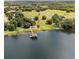 Breathtaking aerial view of a lakeside property with a private dock and surrounding lush greenery at 9400 Laws Road, Clermont, FL 34714