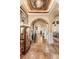 Elegant hallway with arched doorways, display cases, and travertine flooring at 9400 Laws Road, Clermont, FL 34714