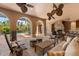 Covered outdoor patio with a stone fireplace, comfortable seating, and scenic pool views at 9400 Laws Road, Clermont, FL 34714