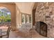 Covered outdoor living space featuring a stone fireplace and serene garden views at 9400 Laws Road, Clermont, FL 34714