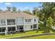 Rear exterior featuring a screened patio and balcony, with a well-kept lawn at 995 Grand Wildmere, Longwood, FL 32750