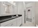 Bathroom showcasing a vanity with dark countertop and white cabinets and access to closet and shower at 995 Grand Wildmere, Longwood, FL 32750