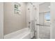 Bathroom tub and shower combination with white tile and a window offering natural light at 995 Grand Wildmere, Longwood, FL 32750