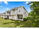 Back exterior showing a spacious lawn and outdoor patio with a balcony above at 995 Grand Wildmere, Longwood, FL 32750