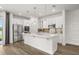 Modern kitchen with stainless steel appliances, white cabinetry, and a large island at 995 Grand Wildmere, Longwood, FL 32750