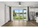 Bright living room with sliding glass doors offering serene water views and stainless steel appliances nearby at 995 Grand Wildmere, Longwood, FL 32750