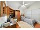 Cozy bedroom with hardwood floors, unique ceiling fan, and built in wood shelves and wardrobe at 1752 Challenger Ave, Davenport, FL 33897