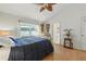 Cozy bedroom featuring hardwood floors, natural light, ceiling fan, and ensuite bathroom access at 1752 Challenger Ave, Davenport, FL 33897