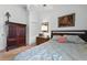 Bedroom with wood wardrobe, bedside table with lamp and bed with pink accent pillow at 1752 Challenger Ave, Davenport, FL 33897