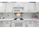 Bright kitchen featuring white cabinets, marble countertops, and modern appliances at 1752 Challenger Ave, Davenport, FL 33897