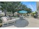 Inviting patio with ample seating, a large shade tree, and an umbrella at 1752 Challenger Ave, Davenport, FL 33897