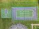 An aerial shot showcases tennis and basketball courts, providing athletic facilities within a well-kept community setting at 10675 Fairhaven Way, Orlando, FL 32825