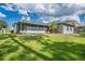 Backyard view with a screened-in patio, some grass, and trees at 10675 Fairhaven Way, Orlando, FL 32825