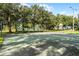 A well-maintained basketball court surrounded by mature trees offers a recreational space for sports and outdoor activities at 10675 Fairhaven Way, Orlando, FL 32825