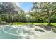 Outdoor basketball court featuring a well-maintained playing surface and surrounding trees at 10675 Fairhaven Way, Orlando, FL 32825