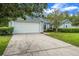 View of the home with a spacious driveway, two-car garage, and manicured front yard at 10675 Fairhaven Way, Orlando, FL 32825