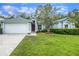 Charming one-story home featuring a two-car garage, well-maintained lawn, and mature landscaping at 10675 Fairhaven Way, Orlando, FL 32825