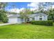 Landscaped front yard with healthy lawn and shade tree at 10675 Fairhaven Way, Orlando, FL 32825