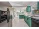Bright kitchen featuring green cabinets, stainless steel appliances and view of the living room at 10675 Fairhaven Way, Orlando, FL 32825