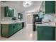 This kitchen offers green cabinets, stainless steel appliances, and white countertops for a modern feel at 10675 Fairhaven Way, Orlando, FL 32825