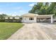 Inviting home exterior with a well-manicured lawn and convenient covered parking at 1204 Marie Ave, Apopka, FL 32703