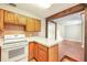 Open-concept kitchen featuring wood cabinetry, durable countertops, plus a view to the adjacent room at 1204 Marie Ave, Apopka, FL 32703