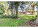 Lush backyard featuring mature trees, a quaint gazebo, and a view of the home's exterior at 123 Se 1St Ave, Webster, FL 33597