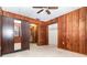 Cozy bedroom with wood paneling, ceiling fan and access to another room and walk-in closet at 123 Se 1St Ave, Webster, FL 33597