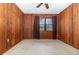 Wood paneled bedroom featuring a ceiling fan and a window with blinds and curtains at 123 Se 1St Ave, Webster, FL 33597