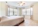 Bright bedroom with multiple windows, a ceiling fan, and neutral tile floors and walls at 123 Se 1St Ave, Webster, FL 33597
