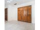 Bedroom featuring neutral tile flooring, a ceiling fan, and a closet with paneled doors at 123 Se 1St Ave, Webster, FL 33597