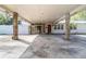 View of carport showing stone columns, concrete slab, and house number at 123 Se 1St Ave, Webster, FL 33597