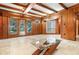 Cozy living room featuring wood paneling, beamed ceilings, and a glass-topped coffee table at 123 Se 1St Ave, Webster, FL 33597