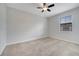 This bedroom features neutral carpet, a ceiling fan, and a window with blinds at 1246 Payne Stewart Dr, Davenport, FL 33896