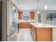Lovely kitchen features stainless steel appliances, wooden cabinets, white countertops and island at 1246 Payne Stewart Dr, Davenport, FL 33896