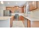 Modern kitchen features stainless steel appliances, wooden cabinets, tile backsplash, and a sink at 1246 Payne Stewart Dr, Davenport, FL 33896