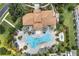 Aerial view of a kidney-shaped pool surrounded by lush landscaping, palm trees, and lounge chairs at 1246 Payne Stewart Dr, Davenport, FL 33896