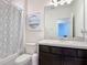 Well-lit bathroom featuring a shower-tub combo and stylish vanity with a framed mirror at 129 Boydfield Ln, Davenport, FL 33837