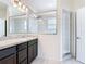 Bright bathroom with a double vanity, large mirror, and walk-in shower at 129 Boydfield Ln, Davenport, FL 33837