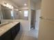 Well-lit bathroom with a double vanity, tiled shower, and glass door, offering a sleek and modern space at 129 Boydfield Ln, Davenport, FL 33837