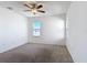 Spacious bedroom with neutral carpet, ceiling fan, and natural light from two windows at 129 Boydfield Ln, Davenport, FL 33837