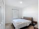 Simple bedroom with a metal bed frame and carpet, featuring a window and closet for storage at 129 Boydfield Ln, Davenport, FL 33837