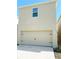 Attached two-car garage with traditional style door and neutral exterior paint at 129 Boydfield Ln, Davenport, FL 33837