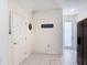 Hallway with access to a kitchen featuring modern appliances and ample space, leading to an outside door at 129 Boydfield Ln, Davenport, FL 33837