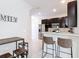 Modern kitchen featuring dark cabinets, stainless steel appliances, and bar seating with an adjacent dining area at 129 Boydfield Ln, Davenport, FL 33837