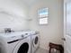 Functional laundry room with a washer, dryer, and overhead shelf, maximizing space and convenience at 129 Boydfield Ln, Davenport, FL 33837